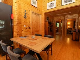 A dining area with a wooden table and four chairs in a wooden interior at Esk Lodge in Salen Isle Of Mull