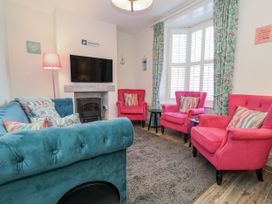 A living room with seating and a television at Shrimp Cottage in Brewers Quay Harbour