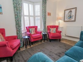 A living room with pink chairs and a lamp at Shrimp Cottage in Brewers Quay Harbour