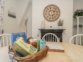 A dining room with a wooden table and clock at Shrimp Cottage in Brewers Quay Harbour