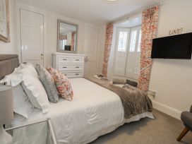 A bedroom with a bed and dresser at Shrimp Cottage in Brewers Quay Harbour