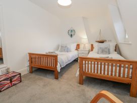 A bedroom with twin beds and a decorative sign at Shrimp Cottage in Brewers Quay Harbour