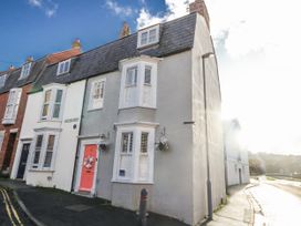 A house with a pink door on a street at Shrimp Cottage in Brewers Quay Harbour