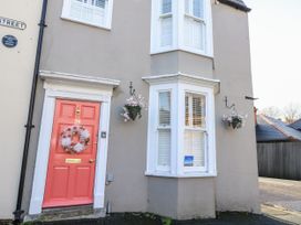 An entrance with a pink door and window at Shrimp Cottage, Brewers Quay Harbour