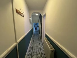 A hallway with a hook rack and radiator at Shrimp Cottage in Brewers Quay Harbour