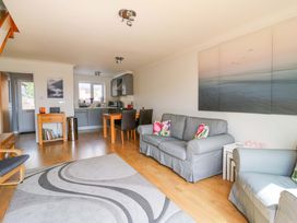 A living room with a sofa and kitchen area at Kingsmere in Norwich