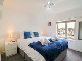 A bedroom with a bed and a window overlooking boats at Kingsmere in Norwich