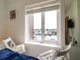 A bedroom with a window view of boats at Kingsmere in Norwich
