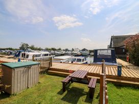 An outdoor area with boats at a dock and a shed at Kingsmere in Norwich