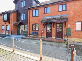 An outdoor view of a brick house with a bench and mailbox at Kingsmere Norwich
