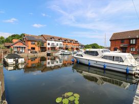 A canal with boats and townhouses at Kingsmere in Norwich