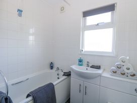 A bathroom with a bathtub sink window and toilet rolls stacked on a counter at Chalet 37 in Hemsby