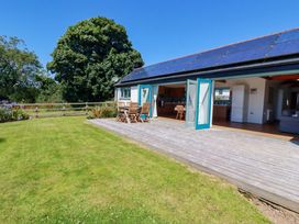 An outdoor area with wooden deck and table with chairs at Little Chywoon Barn Truro
