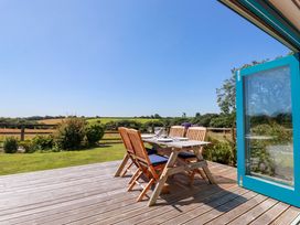 An outdoor dining area with a table and chairs at Little Chywoon Barn in Truro