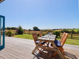 An outdoor patio with a table and chairs at Little Chywoon Barn in Truro