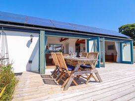 An outdoor dining area with a table and chairs at Little Chywoon Barn in Truro