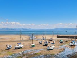 Beach with sailboats on the shore and people walking at 3 Glyn Y Mor Llanbedrog