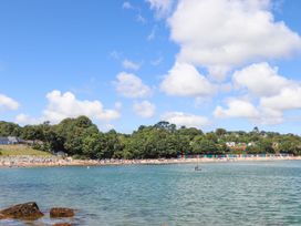 A beach with huts and people at 3 Glyn Y Mor Llanbedrog