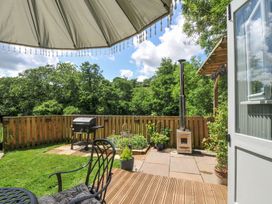 A garden patio with a barbecue grill and plants at The Highwood Hut near Liskeard