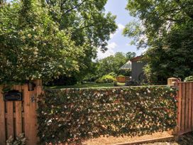 A garden with a wooden gate and fence at The Highwood Hut near Liskeard