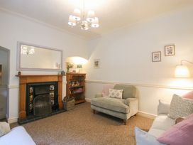 A living room with a fireplace and bookshelf at 2 Aqueduct Cottages Chirk Bank near Chirk