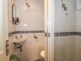 A bathroom with a sink, toilet, and shower at 2 Aqueduct Cottages Chirk Bank near Chirk