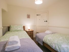 A bedroom with two single beds and a bedside table at 2 Aqueduct Cottages Chirk Bank near Chirk