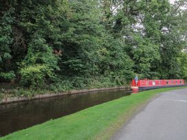 A narrowboat on a canal by trees at 2 Aqueduct Cottages Chirk Bank near Chirk