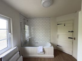 A bathroom with a bathtub and shower at 2 Aqueduct Cottages Chirk Bank near Chirk