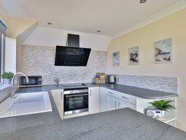 A kitchen with a countertop sink stove oven microwave and kettle at Beer View Cottage in Beer