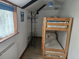 A bedroom with a bunk bed and curtains at The Coach House in Redruth