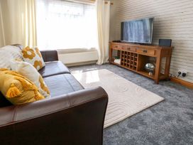 A living room with a sofa and television at Lily's Pad in Weston, Portland