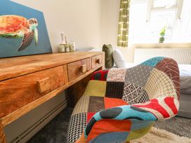 A living room with a desk and colorful chair at Lily's Pad in Weston, Portland