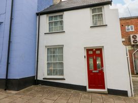 A building exterior with a red door and windows at No.23 Queen St Aberystwyth