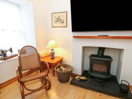 A living room with a rocking chair and a fireplace at No.23 Queen St in Aberystwyth
