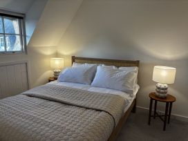 A bedroom with a bed and bedside lamps at Bracken Cottage