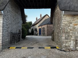 An outdoor area with stone walls and a thatched roof at Bracken Cottage