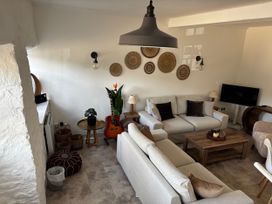A living room with a sofa, coffee table, and television at Bracken Cottage in Osmington