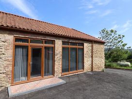 An outdoor space with a brick wall and windows at Birch Cottage in Scarborough
