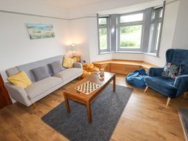 A living room with a sofa a blue armchair bean bags and a coffee table with a board game at Segrwyd Uchaf in Denbigh near Conwy