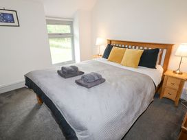 A bedroom with a double bed two bedside tables with lamps and a window at Segrwyd Uchaf in Denbigh near Conwy
