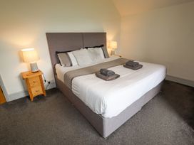 A bedroom with a double bed with towels on the bed and bedside tables with lamps at Segrwyd Uchaf in Denbigh near Conwy