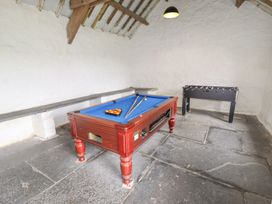 A game room with a pool table and foosball table at Segrwyd Uchaf in Denbigh near Conwy