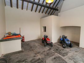 A room with two toy tractors a countertop with sports equipment and a fire extinguisher at Segrwyd Uchaf in Denbigh near Conwy