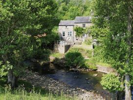 A house with a garden next to a stream at Whinstone Cottage Esk Valley near Grosmont