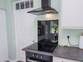 A kitchen with a cooker and extractor hood at Whinstone Cottage Esk Valley near Grosmont