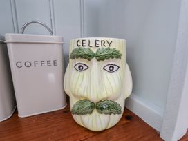 A celery-shaped mug next to a coffee tin at Whinstone Cottage Esk Valley near Grosmont
