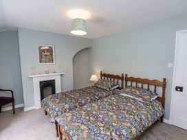 A bedroom with two beds and a fireplace at Whinstone Cottage Esk Valley near Grosmont
