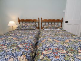 A bedroom with two beds and a lamp at Whinstone Cottage Esk Valley near Grosmont