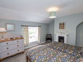 A bedroom with a bed and dresser at Whinstone Cottage in Esk Valley near Grosmont